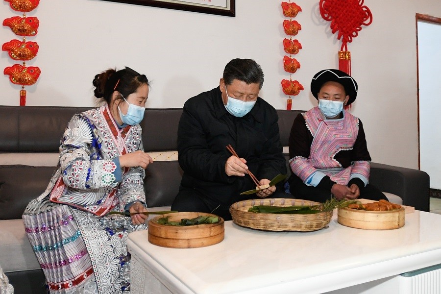 2021年2月3日下午，習(xí)近平在貴州畢節(jié)市黔西縣新仁苗族鄉(xiāng)化屋村苗族村民趙玉學(xué)家，同一家人邊聊家常邊制作當(dāng)?shù)貍鹘y(tǒng)節(jié)日食品黃粑。新華社記者 李學(xué)仁 攝