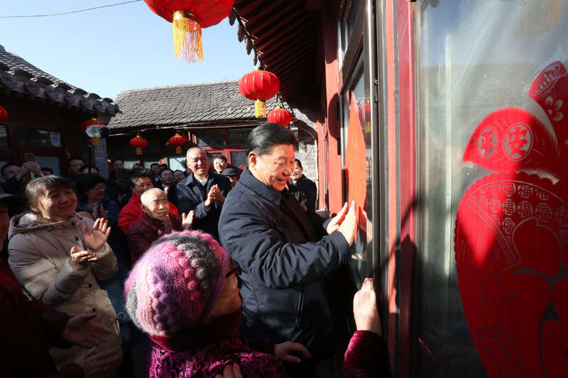 2019年2月1日上午，習(xí)近平在北京前門(mén)東區(qū)草廠四條胡同32號(hào)院，高興地拿起一幅“?！弊?，親自貼到門(mén)上，給這里的老街坊們拜年。新華社記者 鞠鵬 攝